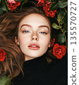 Portrait of beautiful woman amongst red roses backdrop 135570727