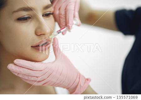 Cosmetologist with a prick. Woman with cosmetologist. Lady in a beauty studio. 135571069