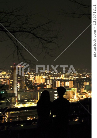 從花岡山展望台眺望熊本市的約會之夜景色-情侶們俯瞰城市的剪影 從花岡山展望台眺望熊本市的約會之夜景色-情侶們俯瞰城市的剪影 135571211