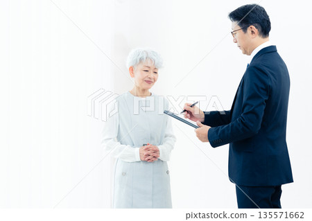 一位老婦人正在聽銷售員的講解 135571662