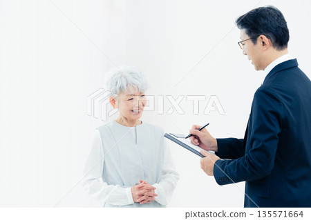 一位老婦人正在聽銷售員的講解 135571664