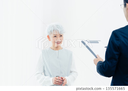 一位老婦人正在聽銷售員的講解 135571665