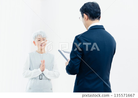 Senior woman listening to a salesperson's explanation 135571667
