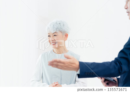 Senior woman listening to a salesperson's explanation Senior woman listening to a salesperson's explanation 135571671