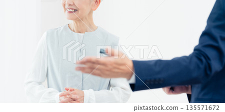 一位老婦人正在聽銷售員的講解 135571672