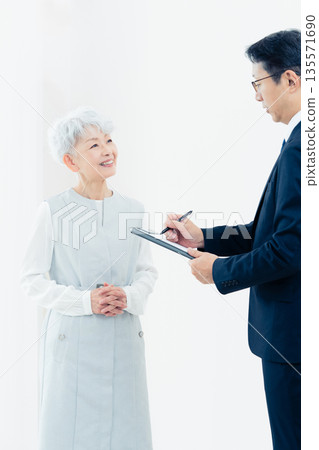 一位老婦人正在聽銷售員的講解 135571690