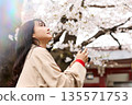 一位年輕的亞洲女性正在欣賞櫻花。 135571753