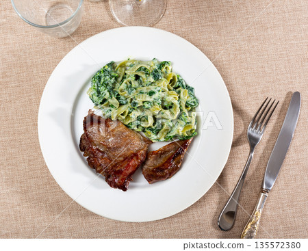 Fried pieces of beef served with pasta Fried pieces of beef served with pasta 135572380