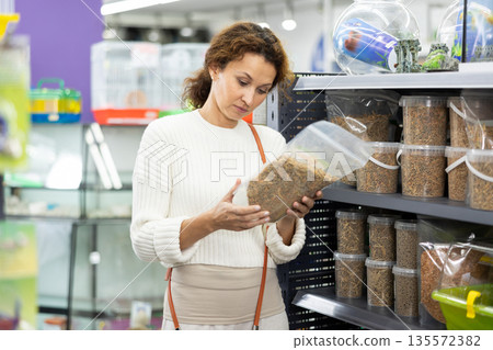 Interested woman choosing nutritious turtle food in pet store Interested woman choosing nutritious turtle food in pet store 135572382