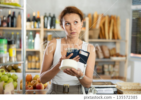 Adult woman scanning qr code of cheese 135572385