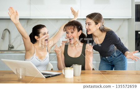 Women are sitting at computer and are immensely happy Women are sitting at computer and are immensely happy 135572659