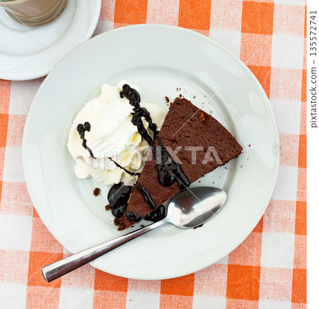 Restaurant serves dessert - ceramic plate accommodates small piece of brownie sponge cake Restaurant serves dessert - ceramic plate accommodates small piece of brownie sponge cake 135572741