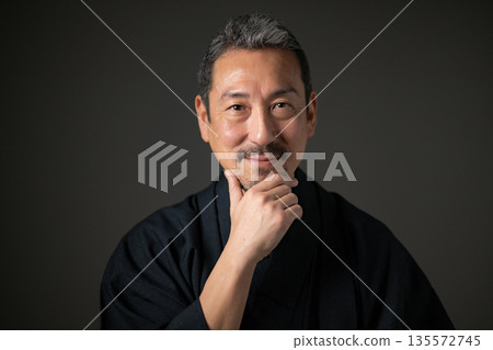 一位微笑的男子在黑色背景下 一位微笑的男子在黑色背景下 135572745