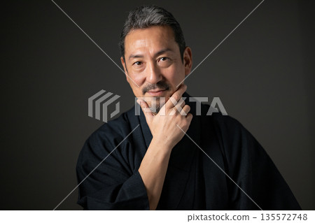 Smiling man against black background Smiling man against black background 135572748