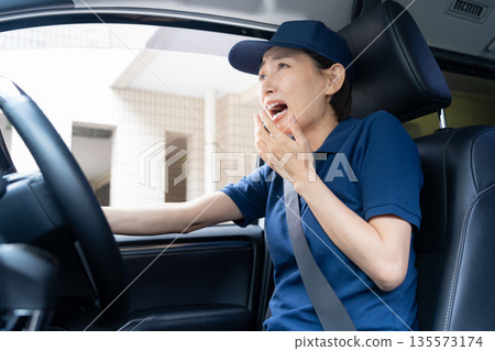 Middle-aged female delivery person delivering packages by car Middle-aged female delivery person delivering packages by car 135573174