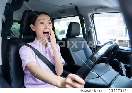 一位中年女性護理員駕車提供居家護理服務。 135573184