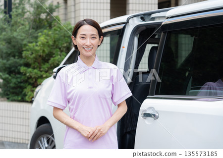 A middle-aged female caregiver providing home care by car 135573185
