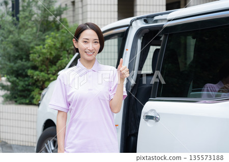 一位中年女性護理員駕車提供居家護理服務。 135573188