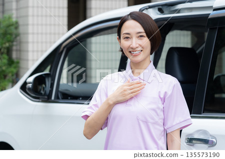 一位中年女性護理員駕車提供居家護理服務。 135573190