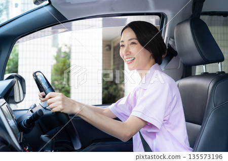 A middle-aged female caregiver providing home care by car A middle-aged female caregiver providing home care by car 135573196