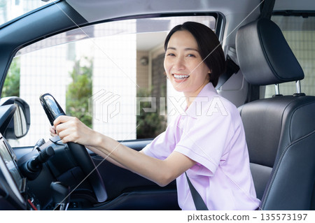 A middle-aged female caregiver providing home care by car A middle-aged female caregiver providing home care by car 135573197