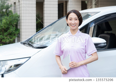 A middle-aged female caregiver providing home care by car 135573206