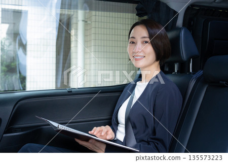 一位中年女商人駕車出遊。 135573223