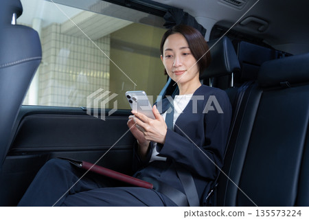 一位中年女商人駕車出遊。 135573224