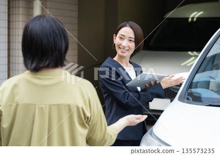 一位中年女商人正在評估一輛車 135573235