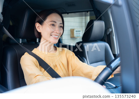 Middle-aged woman driving a car 135573240