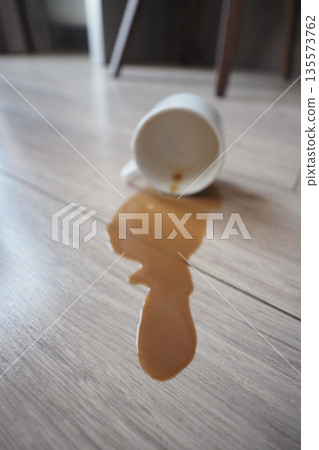 Coffee spills on the floor near a chair in a cafe Coffee spills on the floor near a chair in a cafe 135573762