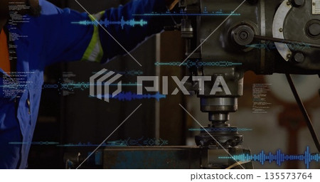 Operating machinist wearing blue coveralls adjusting mill controls at workshop, with code overlays Operating machinist wearing blue coveralls adjusting mill controls at workshop, with code overlays 135573764
