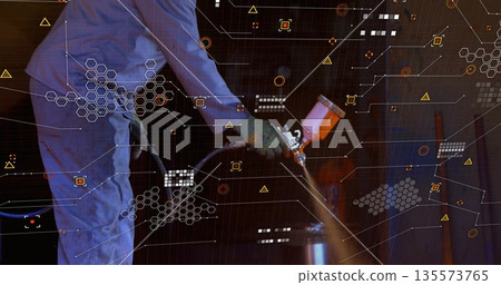 Spraying barrel by painter wearing coverall, gloves in workshop with spray gun and digital graphics 135573765