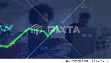 Two professionals analyzing data in open-plan office, with laptop, documents and line graph overlay Two professionals analyzing data in open-plan office, with laptop, documents and line graph overlay 135573787