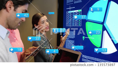 Gesturing team member in blazer presenting data on touchscreen at meeting, tablet reaction icons Gesturing team member in blazer presenting data on touchscreen at meeting, tablet reaction icons 135573897