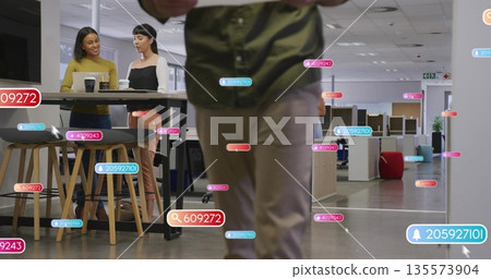 Walking man wearing green shirt khaki pants through open office space, with floating data labels 135573904