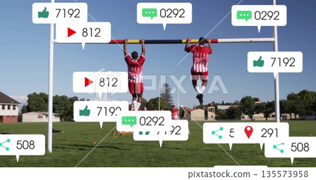 Training soccer players gripping pull-up bar on suburban field, pulling up with media icons Training soccer players gripping pull-up bar on suburban field, pulling up with media icons 135573958