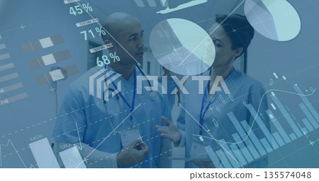 Discussing two medical staff analyzing patient metrics with digital charts in hospital corridor Discussing two medical staff analyzing patient metrics with digital charts in hospital corridor 135574048