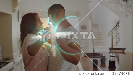 Dancing couple holding hands in modern kitchen, with wooden table, coffee mugs, French press 135574076