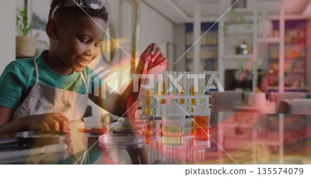 Transferring solution by boy wearing apron goggles into petri dish at home with pipette, copy space Transferring solution by boy wearing apron goggles into petri dish at home with pipette, copy space 135574079