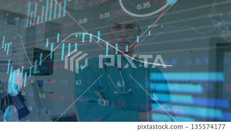 Gazing doctor wearing teal scrubs monitoring stock market chart overlay in hospital, stethoscope 135574177