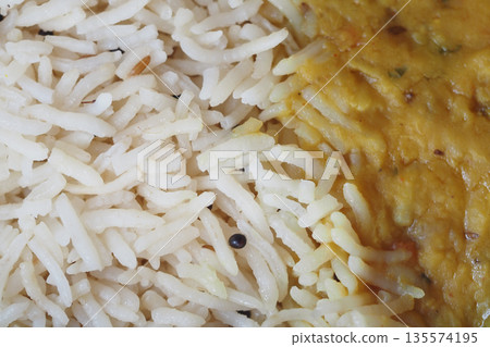 Simple rice served alongside flavorful lentil curry dish Simple rice served alongside flavorful lentil curry dish 135574195