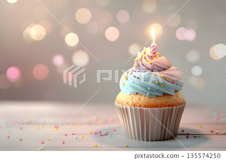 birthday cupcake with lit candle, colorful frosting, sprinkles on top 135574250