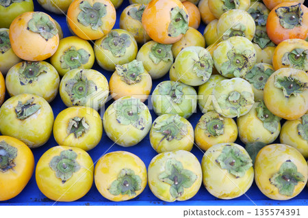 Persimmons arranged neatly on display at a local market in autumn 135574391