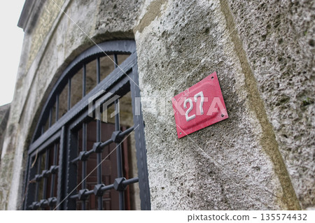 Historic stone wall with number 27 and iron gate details in focus 135574432