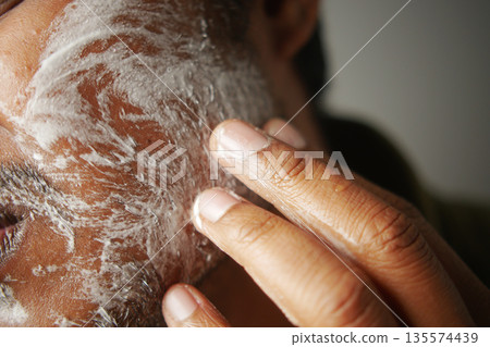 Man applying cleansing product on facial skin during morning routine Man applying cleansing product on facial skin during morning routine 135574439