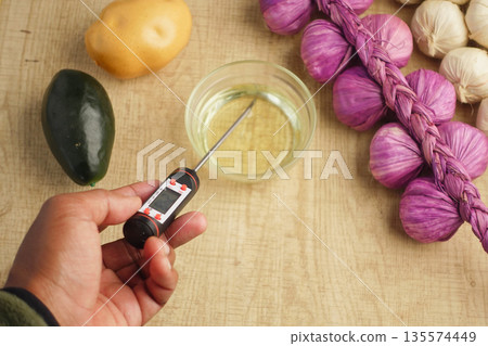 Checking oil temperature for cooking Checking oil temperature for cooking 135574449