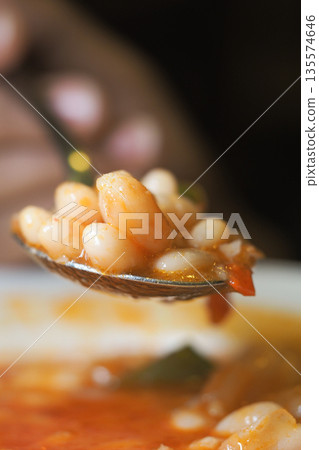 Spoon with beans in sauce shows close view of meal Spoon with beans in sauce shows close view of meal 135574646