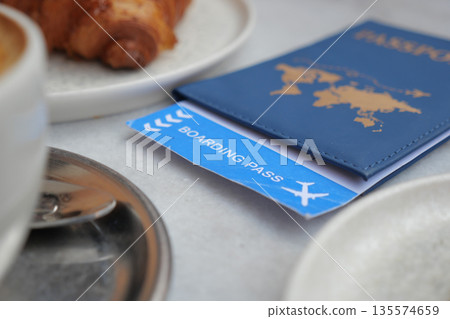 Travel essentials on a table with coffee and pastry 135574659