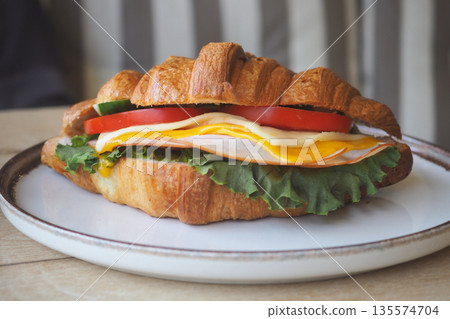 Delicious croissant sandwich with fresh ingredients served Delicious croissant sandwich with fresh ingredients served 135574704